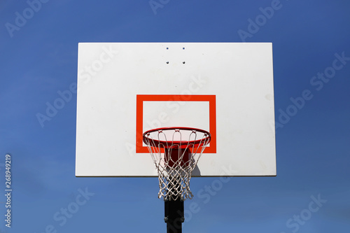 Outdoor Basketball Hoop and Backboard Isolated Against Blue Sky