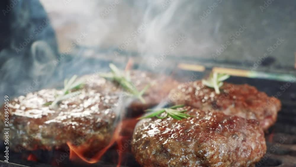 Tasty meat for a burger a barbecue grill. Fire is burning and juicy steak with stripes are become to be ready. Close up of chief cooked tasty burger in casual bar slow motion Tasty meat for a burger a barbecue grill. Fire is burning and juicy steak with stripes are become to be ready. Close up of chief cooked tasty burger in casual bar slow motion