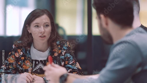Discussion of young promising businessmen. Discussion of creative ideas. Female boss in a meeting room. Shooting through the glass.