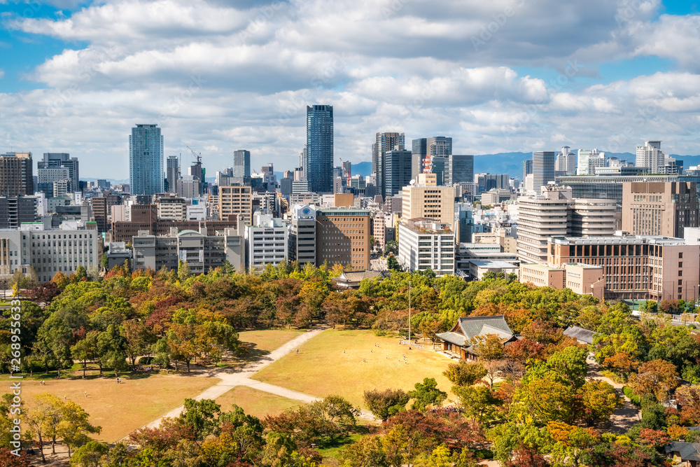 Fototapeta premium Osaka Cityscape in Kansai region, Japan - View from Osaka Castle with the park surrounding the castle in autumn in the foreground.