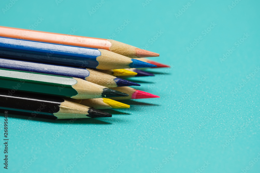 Color Pencils on a pastel cyan paper background. Selective focus