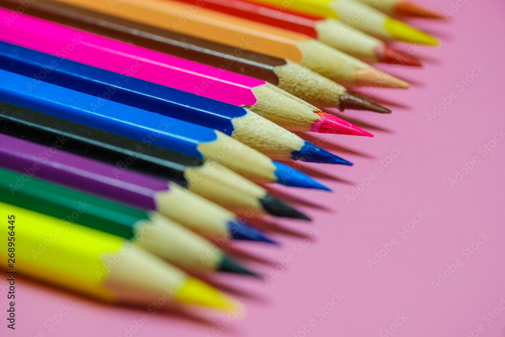 Color Pencils on a pink paper background. Selective focus Color Pencils on a pink paper background. Selective focus