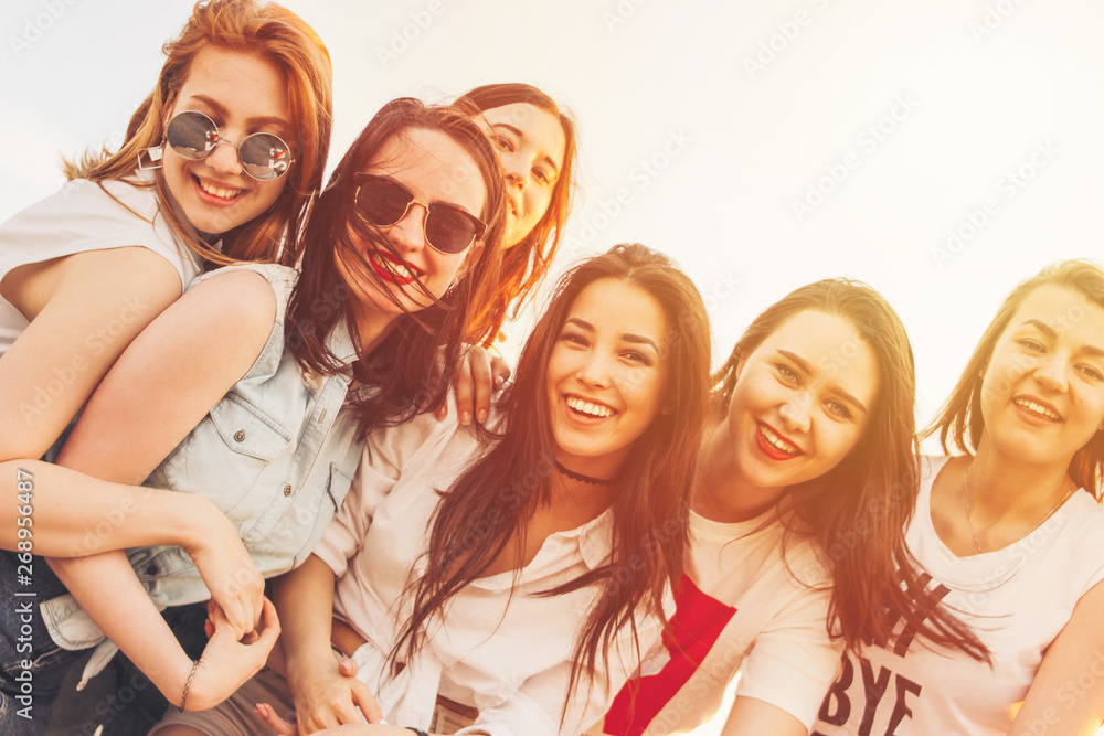 Group of carefree happy girls friends enjoy life on summer city street, sunset sunlight toned background Group of carefree happy girls friends enjoy life on summer city street, sunset sunlight toned background