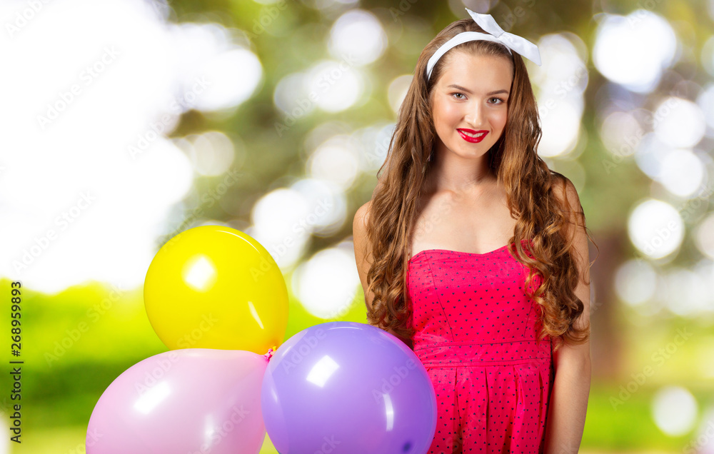 Naklejka premium Smiling woman holding balloon and looking at camera