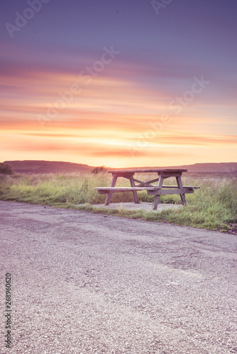 Wooden bench under stunning sunset clouds