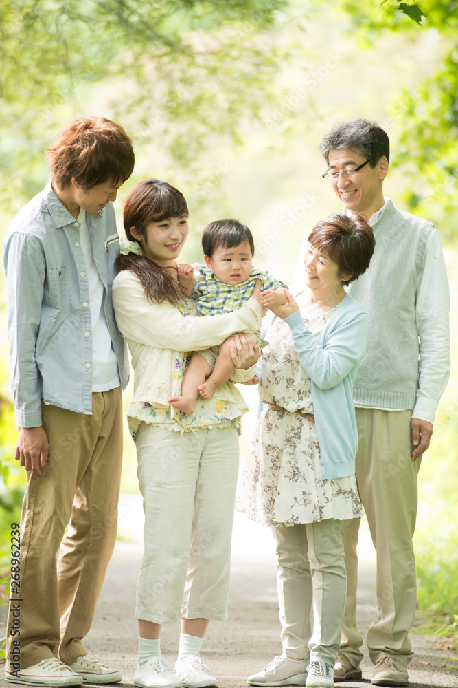新緑の中で微笑む3世代家族