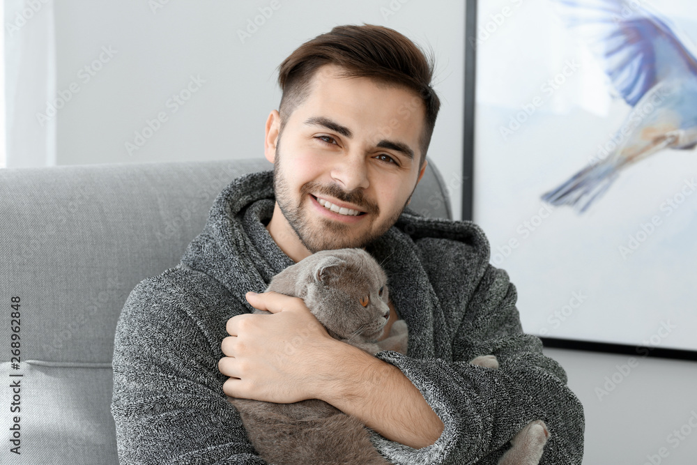 Young man with cute funny cat at home Young man with cute funny cat at home