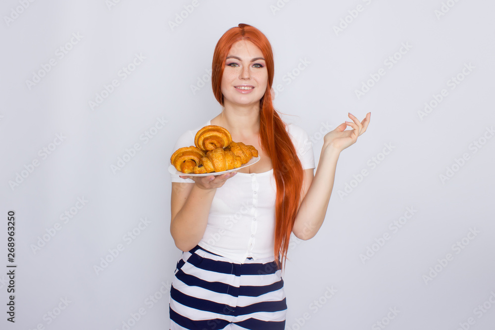 Red haired woman holding plate with croissants Red haired woman holding plate with croissants