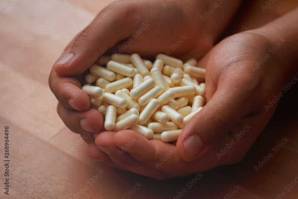 Male hands hold a lot of yellow capsules pills. Male hands hold a lot of yellow capsules pills.