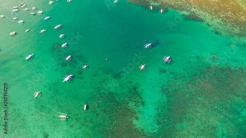Aerial shot of local boats in El Nido Beach, Palawan, Philippines.Many white boats in the turquoise lagoon, view from above.