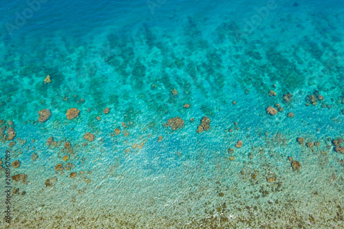 Fototapeta Naklejka Na Ścianę i Meble -  Transparent sea water, top view. Aerial view of calm sea water. Top view of a clean ocean water near a coast.
