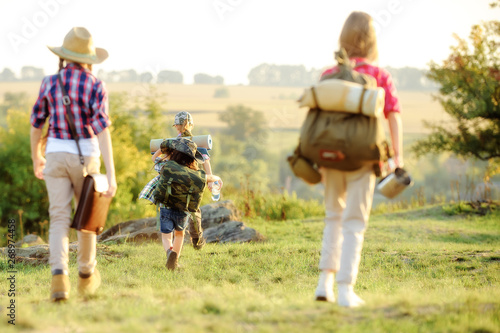 girl in a red shirt with a backpack goes hiking with friends.