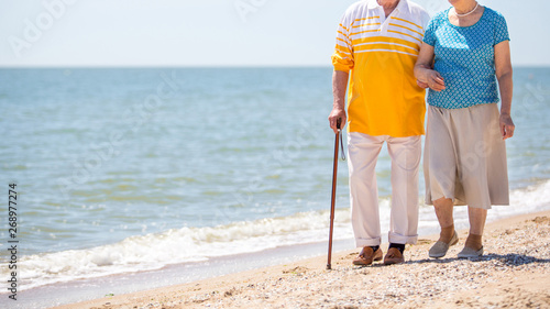 Legs of senior adults walking on the beach