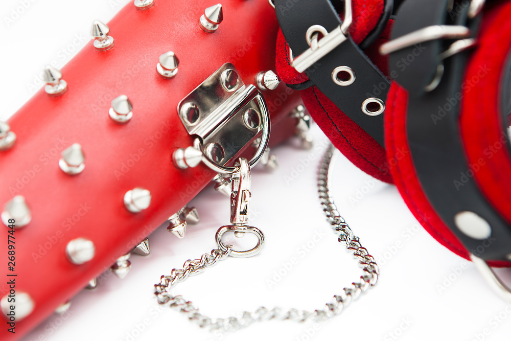 Obraz premium Sex toys for bdsm. Leather handcuffs and clamps for hands with thorns. Isolated handcuffs with chain on white background