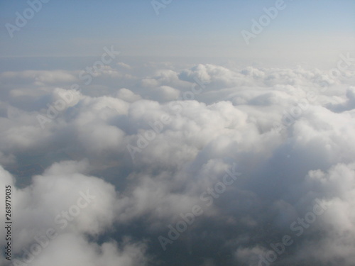 The natural picture of an infinite cloudy valley like an arctic desert is covered with snow dunes under the blue sky.