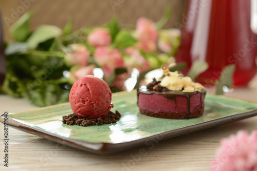 dessert with a scoop of berry ice cream on a wooden table with flower decor