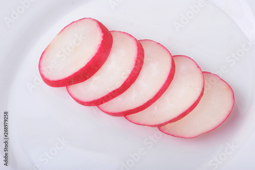 Radish slices isolated on white background on a plate
