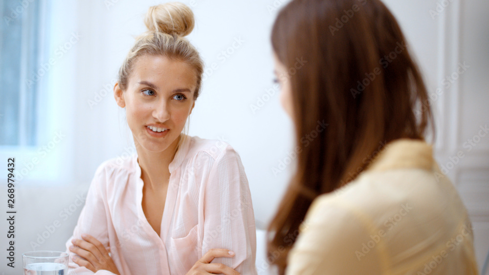 Two cheerful teenage girlfriends talking at home. Two cheerful teenage girlfriends talking at home.