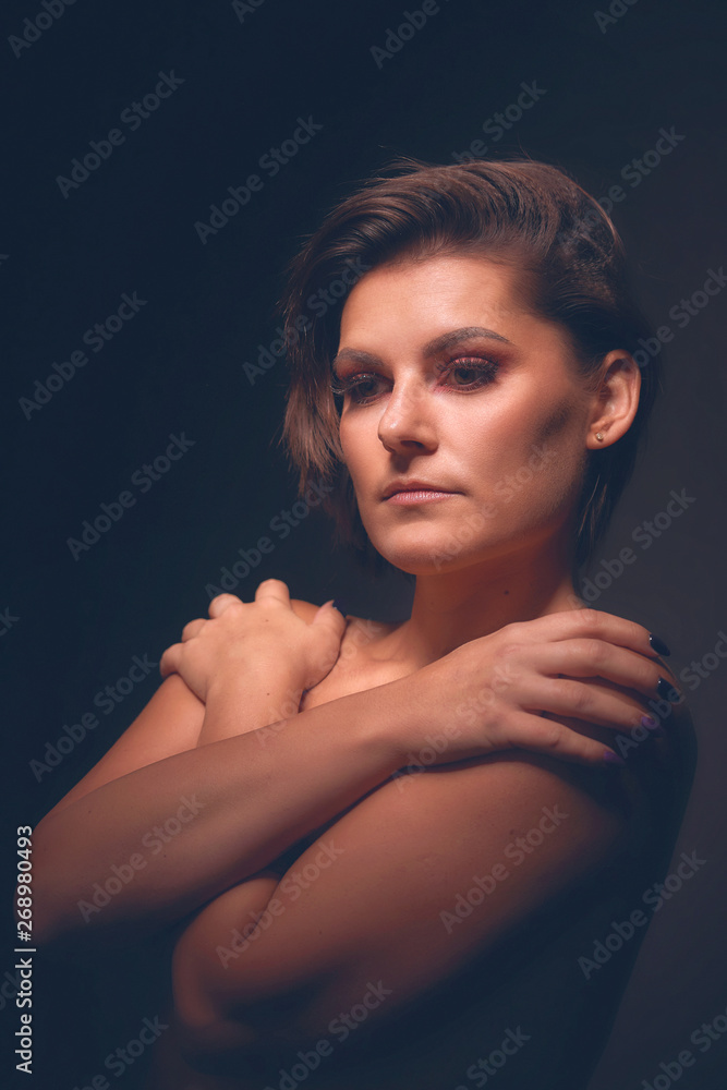 Fototapeta premium Beautiful face of young adult woman with clean fresh skin. black background