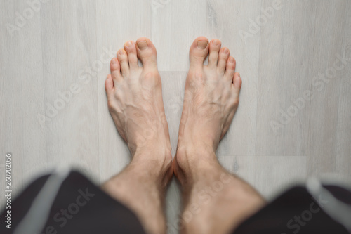 POV, man barefoot on the floor, male legs photo