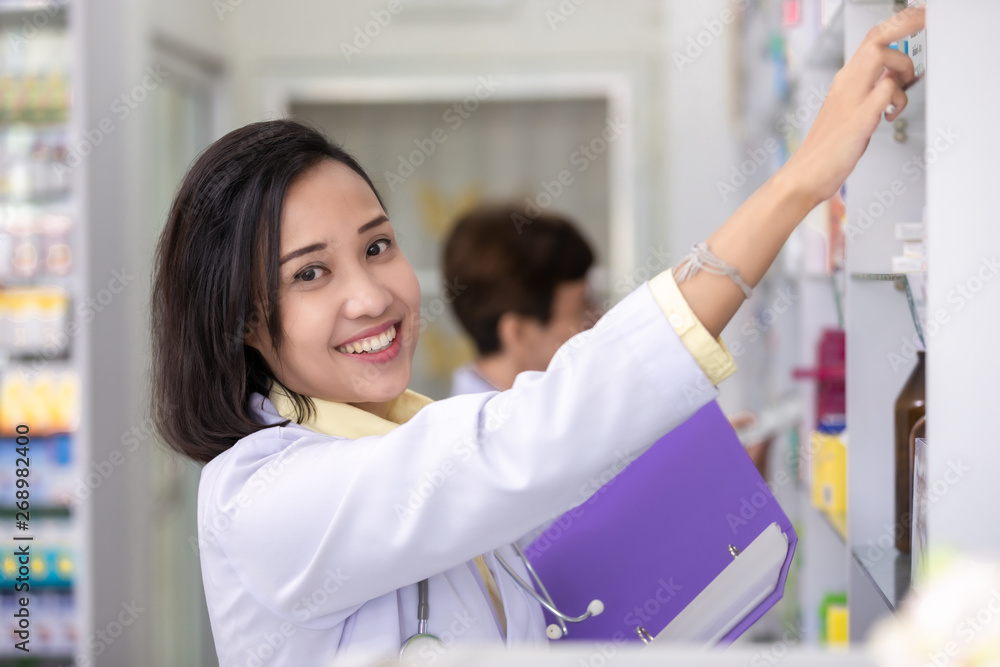 female pharmacies are checking current drugs on the shelves in the store female pharmacies are checking current drugs on the shelves in the store