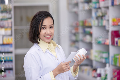 female pharmacies are checking current drugs on the shelves in the store