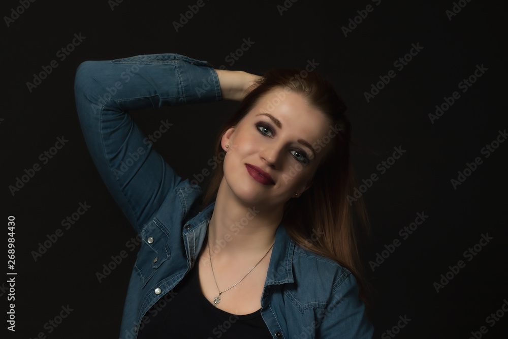 Low key portrait of long hair young woman looking at the camera on the dark background. Low key portrait of long hair young woman looking at the camera on the dark background.