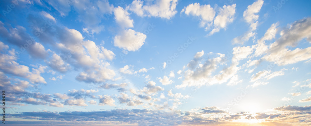 Fototapeta Niebieskie niebo chmur tło. Piękny krajobraz z chmurami i pomarańczowym słońcem na niebie