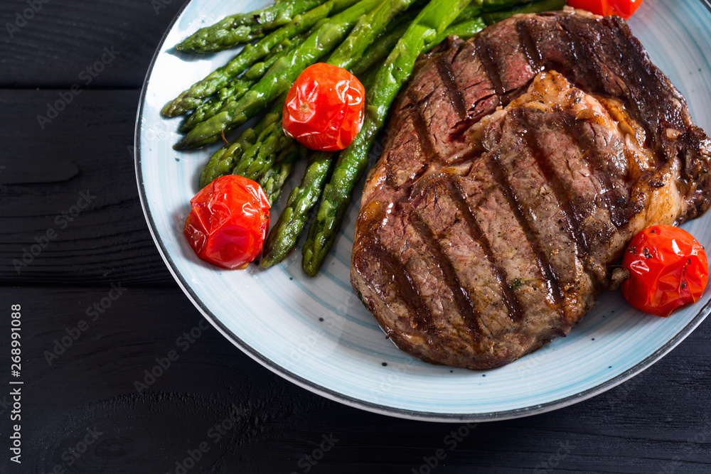Grilled beef steak ribeye with cherry tomatoes and asparagus Grilled beef steak ribeye with cherry tomatoes and asparagus