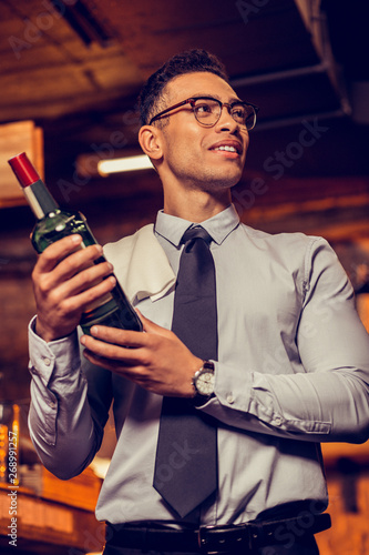 Businessman holding bottle of alcohol opening his bar