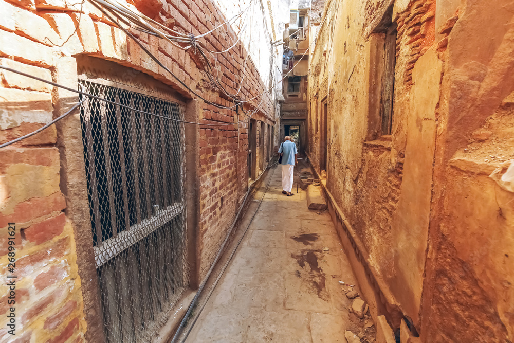 Varanasi narrow alleyway with old residential buildings. Varanasi is known as the oldest city of India with ancient architecture and historic temples