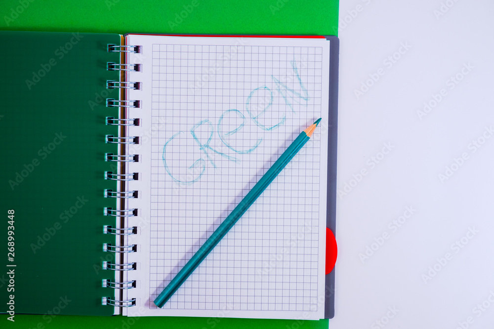 Top view of open spiral blank notebook with pencil on green desk background Top view of open spiral blank notebook with pencil on green desk background