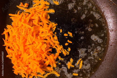 Grated carrot and onion on the frying pan © Denis