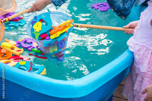 Educational water game for children. Fish in the form of letters of numbers and images of animals and a net for fishing. Fun for kids