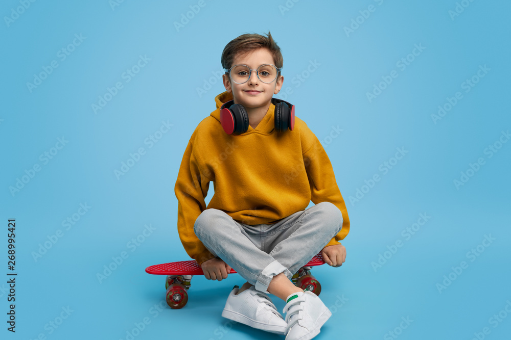Positive youngster sitting on longboard