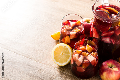 Photo Red wine sangria in glasses on wooden table. Copyspace