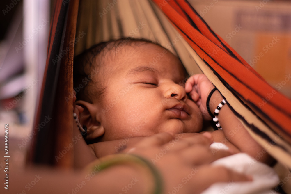 Closeup of cute little new born baby sleeping in cradle made of