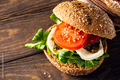 Italian Caprese sandwiches with fresh tomatoes, mozzarella cheese and lamb's lettuce, multigrain bun. Healthy food concept with copy space