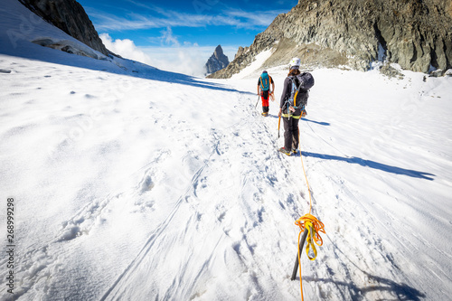 Couple alpinists mountaineers walking glacier  slopes. Mont Blanc.