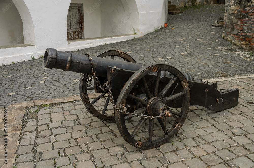 Old antique cannon in the walls of the castle fortress