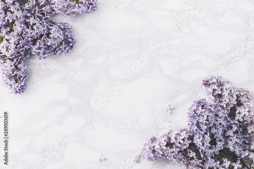 Spring background with lilac flowers on marble background/ Top view.