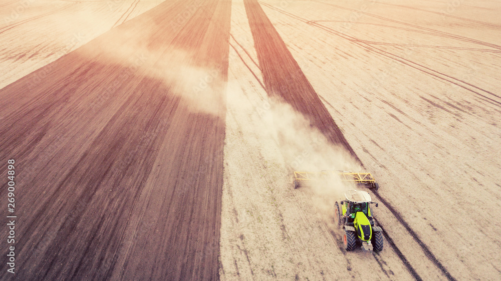 aerial view of tractor , combine cultivating field. drone shot. picture with space for text. Farmland from above aerial view of tractor , combine cultivating field. drone shot. picture with space for text. Farmland from above