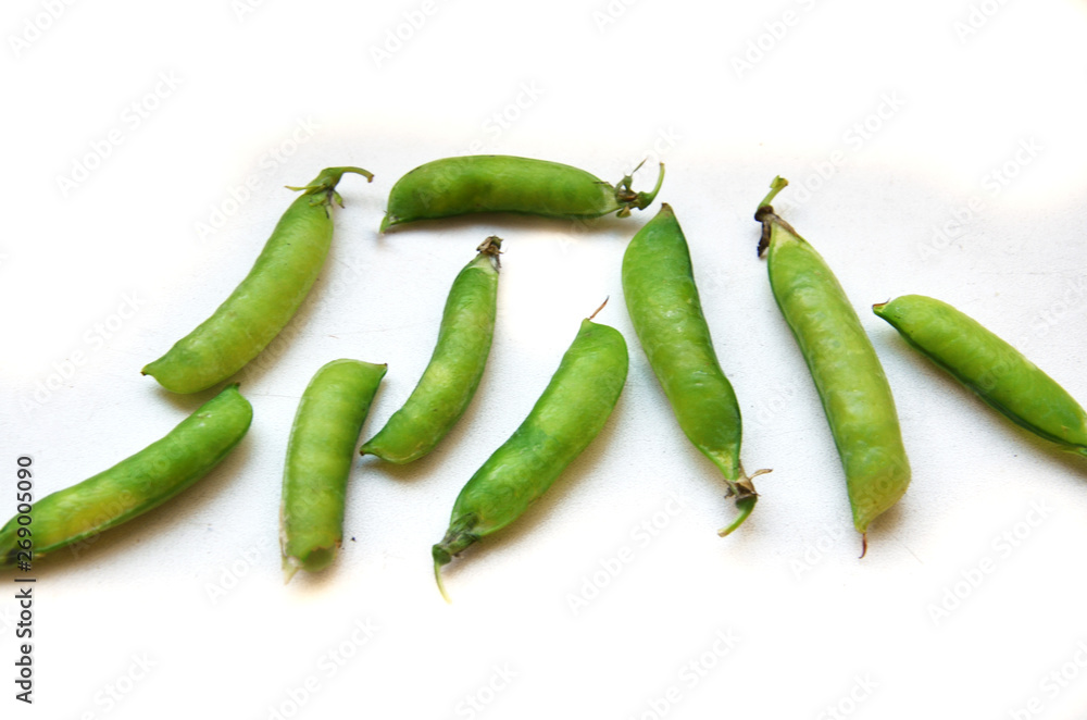 green peas in pods on a white background green peas in pods on a white background