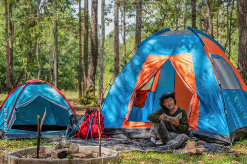 male sitting in front of camping tent in camping activity in forest