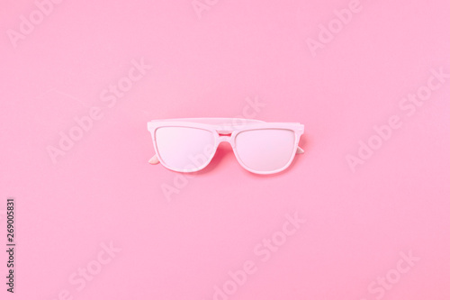Pink glass lie on pastel pink background. Minimal summer concept.