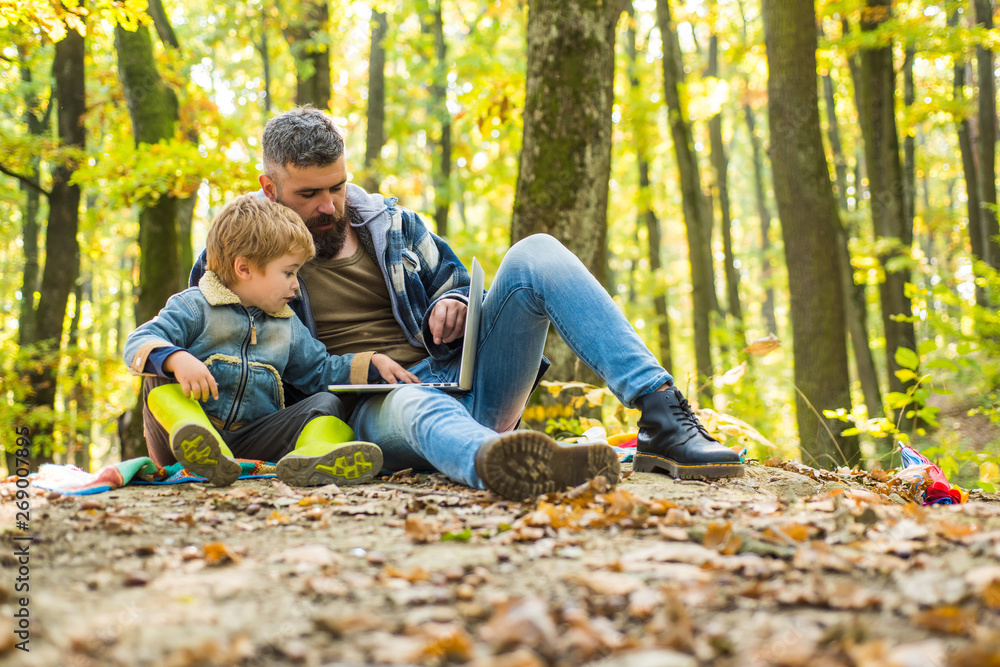 Ecology upbringing. Father teaches son use modern technology. United with nature. Ecology lesson. Forest school and ecology education. Man bearded father and little son with laptop in forest Ecology upbringing. Father teaches son use modern technology. United with nature. Ecology lesson. Forest school and ecology education. Man bearded father and little son with laptop in forest