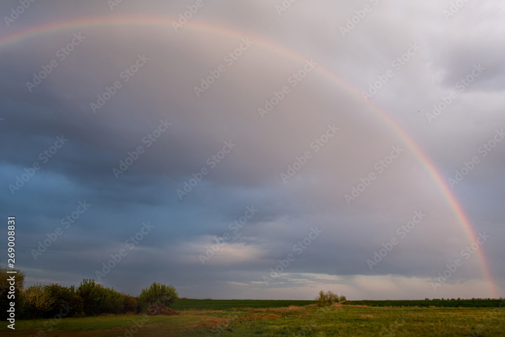 Big rainbow on the backdrop of a rainy sky Big rainbow on the backdrop of a rainy sky