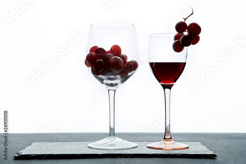  Red grape and wine in crystal glasses on white background