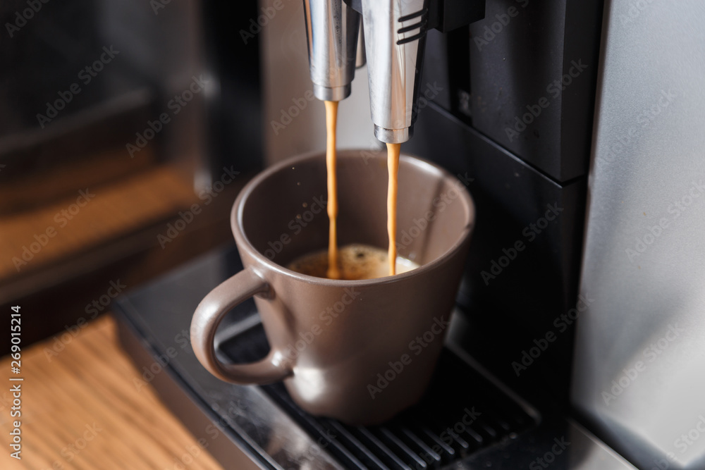 Espresso machine pouring coffee in brown cup. Espresso machine pouring coffee in brown cup.