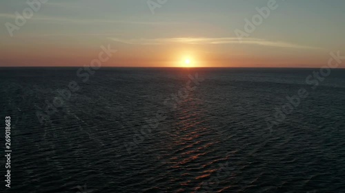 Colorful sunset above the sea surface with waves, aerial drone. Sunset over ocean. Seascap, Summer and travel vacation concept photo